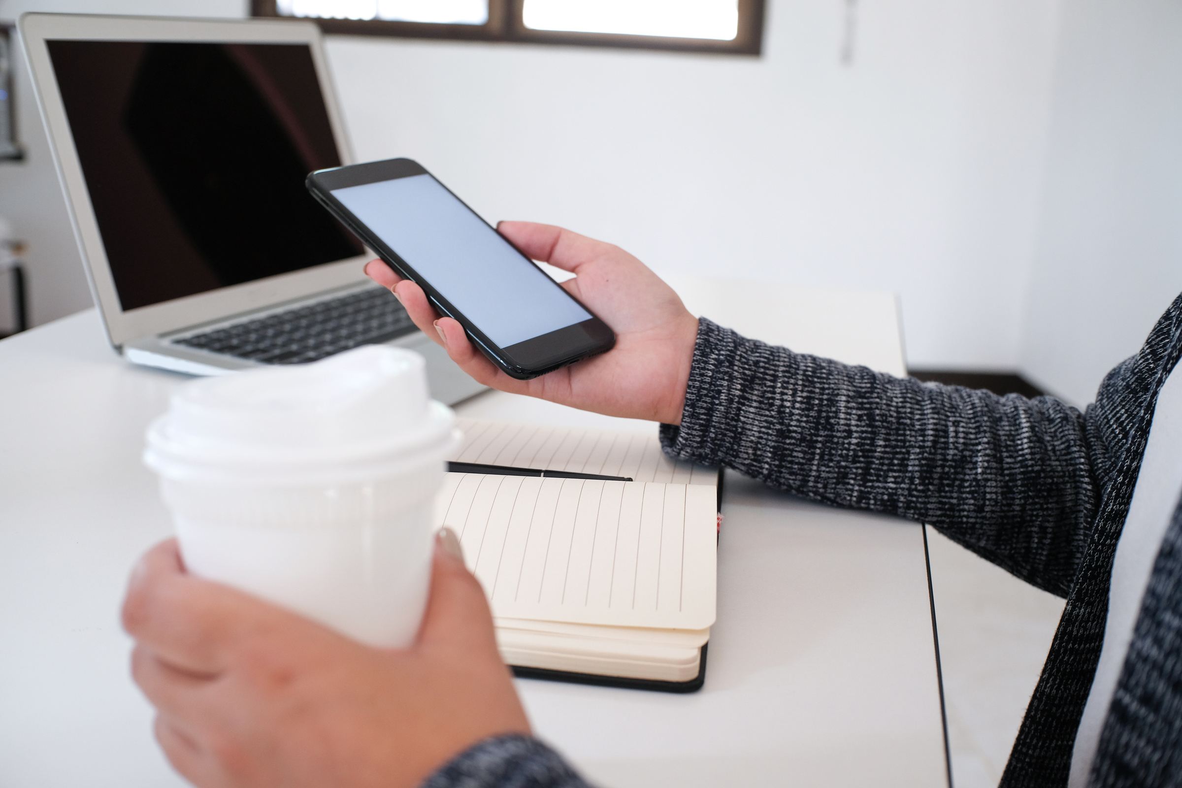 girl using smart phone in office. hand holding smart phone white